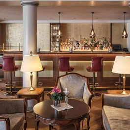 Salon élégant d'hôtel avec bar, fauteuils et éclairage chaleureux