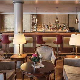 Elegante Hotellounge mit Bar, Sesseln und warmem Beleuchtungskonzept