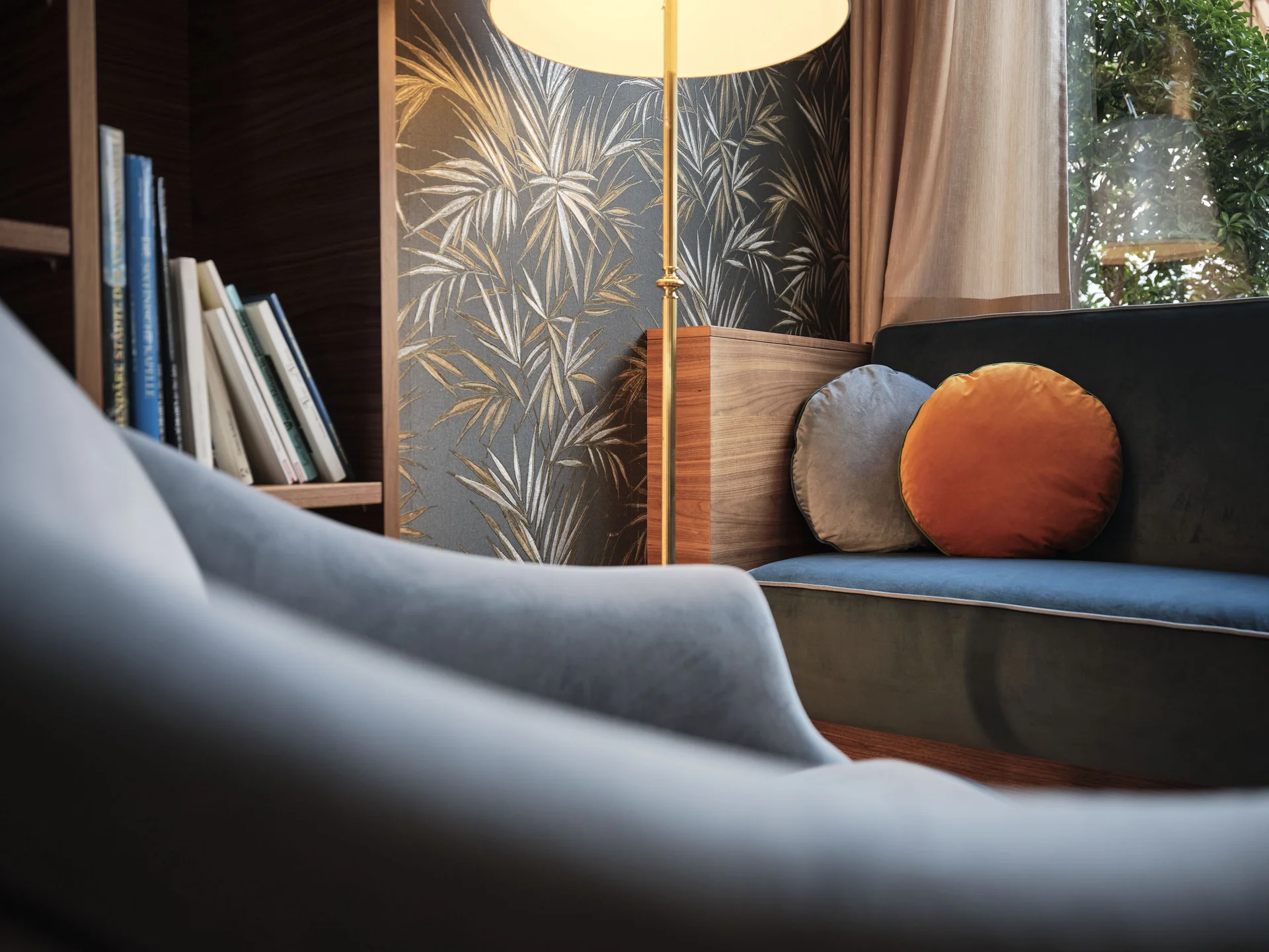 Gemütliche Sitzecke mit Samtsesseln, Sofa, Kissen und eleganter Stehlampe