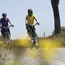 Zwei Frauen fahren Fahrrad auf einem Landweg bei sonnigem Wetter