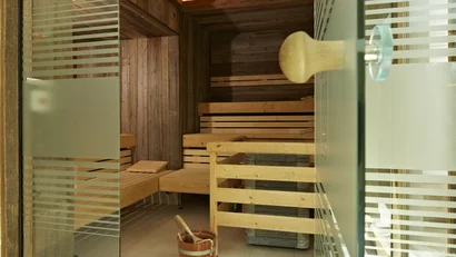 Innenansicht einer Holzsauna mit Eimer und Löffel